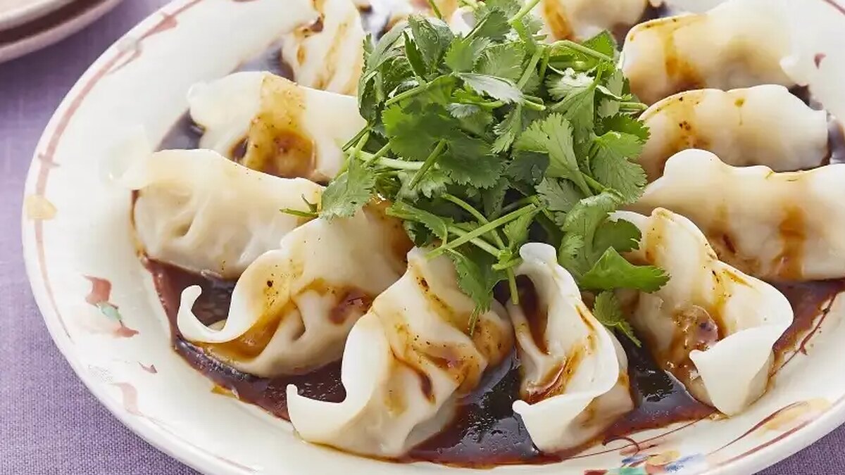大皿に円く並べた水餃子に香味ダレをかけ、中央に香菜をのせた一皿